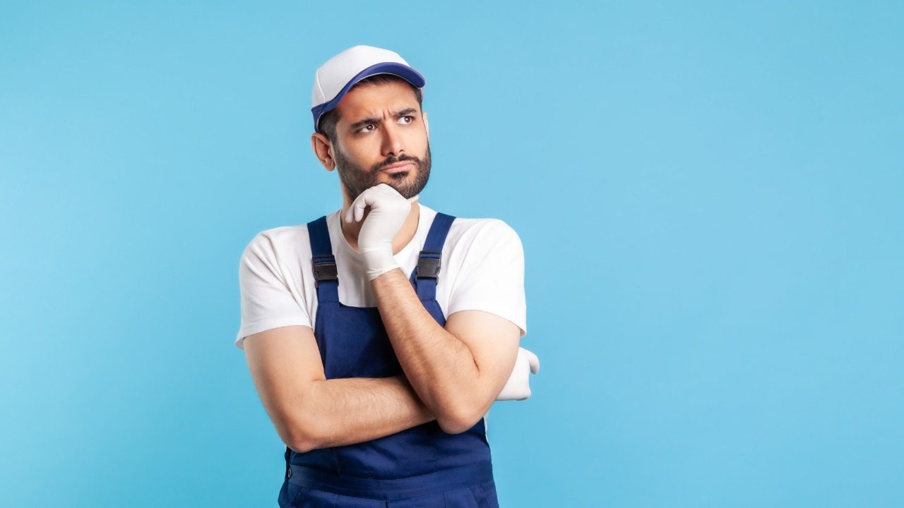 Pensive Confused Handyman In Overalls Holding Chin Thinking Over Decision Having Suspicion